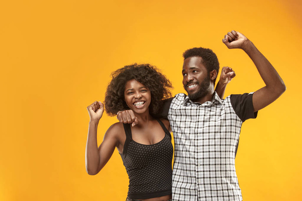 Winning success couple celebrating being a winner. Dynamic energetic image of afro models - Photo, Image