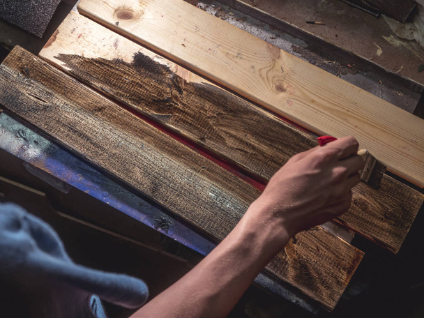 main étroite avec pinceau peignant les barres en bois
 - Photo, image