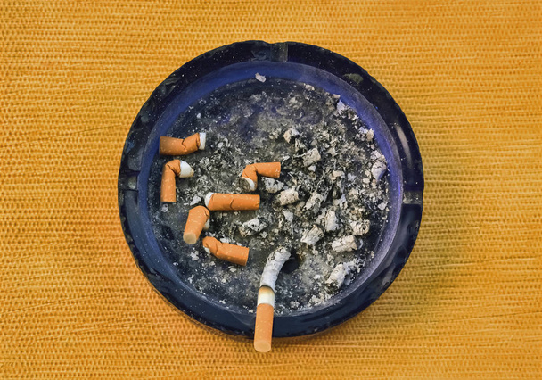 Closeup of an ashtray full of cigarettes viewed from above - Foto, Imagen