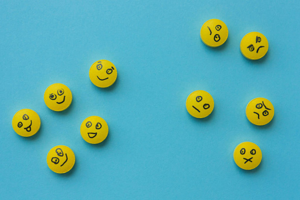 Žluté pilulky s úsměvem, na modrém pozadí. Koncept, myšlenka deprese, zdraví, léčba. Pohled shora, plochá - Fotografie, Obrázek