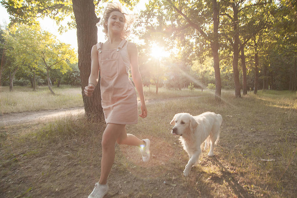 Una chica y una mascota en un paseo por el parque
. - Foto, imagen