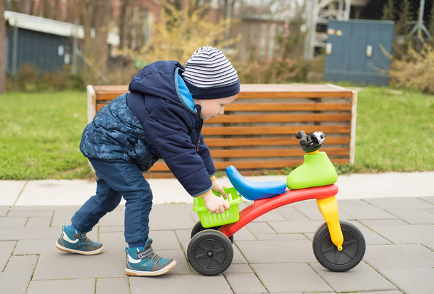 Happy little boy push his bike in the park - Foto, afbeelding