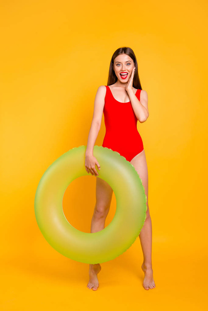 Vertical photo portrait of fit slim with matte colorful lipstick fit slim shouting beautiful lady standing on tiptoes holding big transparent lifebuyo in hand isolated bright vivid background - Фото, зображення