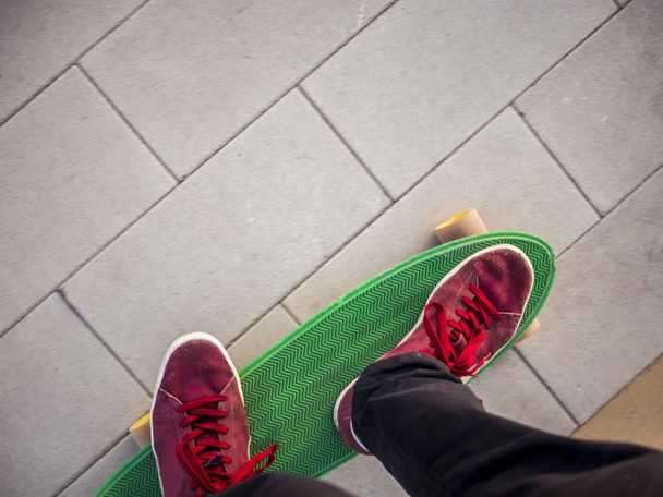 vista superior de duas pernas sobre o plástico penny skate equitação na cidade
 - Foto, Imagem