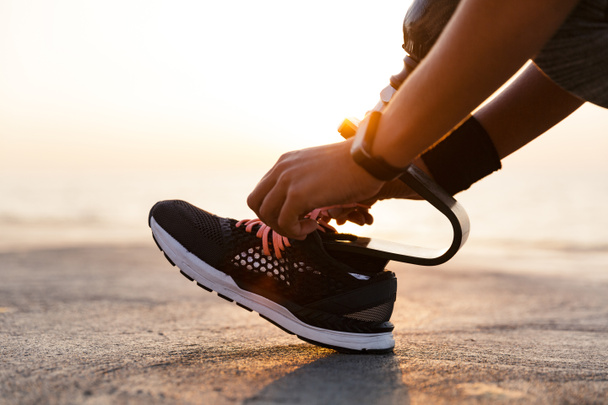 Zár-megjelöl-ból nő fogyatékos sportoló protézis láb a tengerparton szabadtéri cipőfűző árukapcsolás - Fotó, kép