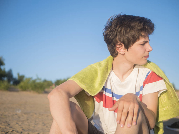 portrait of young smiling man in casual and towel on beach copy space - Photo, Image