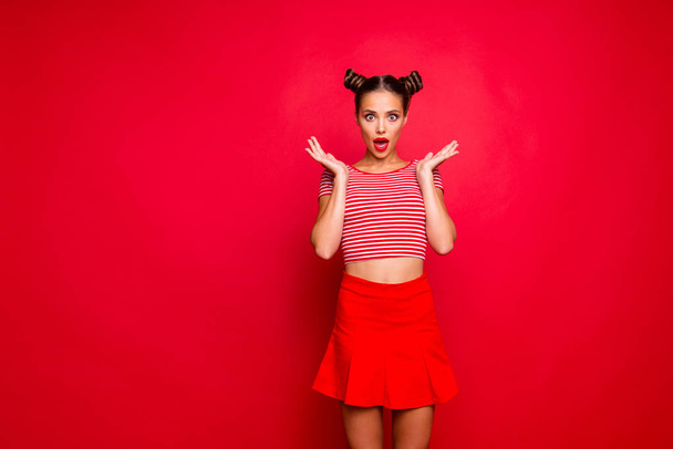 Sporty girl isolated on red background with copy space for text in red skirt and striped shirt impressed by good unexpected news! Concept of human feelings - Foto, afbeelding