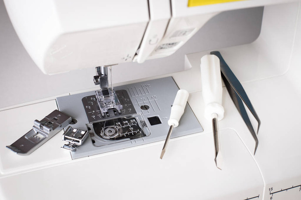 Repair Of Sewing Machine. White Sewing Machine With Tools Of Screwdriver, Tweezers Top View. - Foto, Imagen