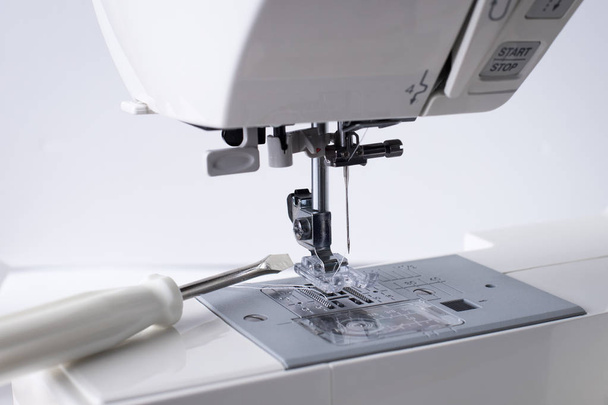 Sewing Machine Repair. White Sewing Machine With Tool Of Screwdriver Close Up. - 写真・画像