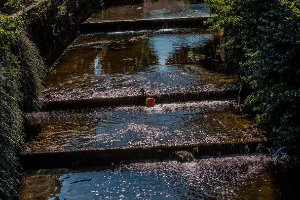 Una bola colorida baila en una escalera de agua
 - Foto, Imagen