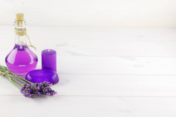 Spa products, aroma candle and lavender flowers on a wooden background - Photo, Image