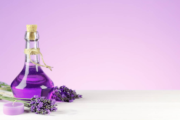 Wellness producten, aroma kaars en lavendel bloemen op een houten achtergrond - Foto, afbeelding