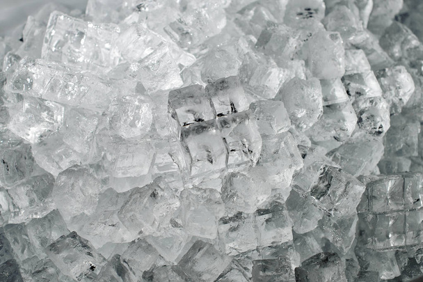 Textured background of a small clear ice cubes lying down in the heap on the ice production plant - Foto, Bild