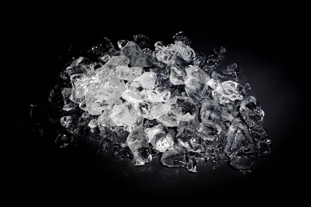 Heap of a small white and transparent ice cubes isolated on the black background starts melt - Φωτογραφία, εικόνα