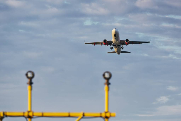 Tráfico en el aeropuerto. Vista de ángulo bajo del avión durante el despegue sobre las luces de aterrizaje
.  - Foto, Imagen