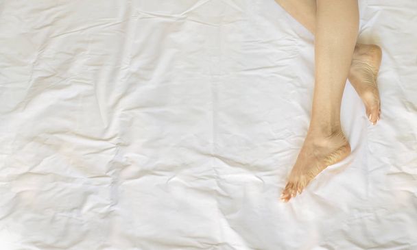Woman legs in white bed sheets - Photo, Image