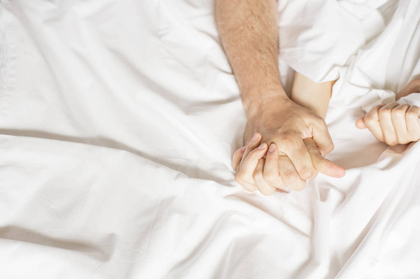 Smyslné krásný mladý pár má sex na posteli. Ženská ruka vytažení bílé listy v extázi, orgasmus. Pojetí lásky. Wellness. Pár v lásce. Koncept orgasmus - Fotografie, Obrázek