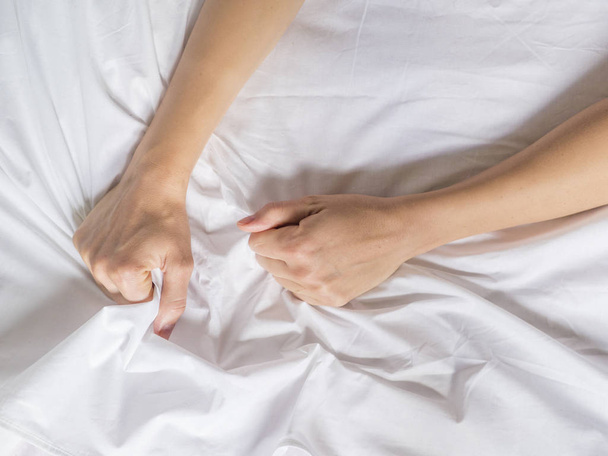 hands of women pulling white sheets in lust and orgasm. - Photo, Image
