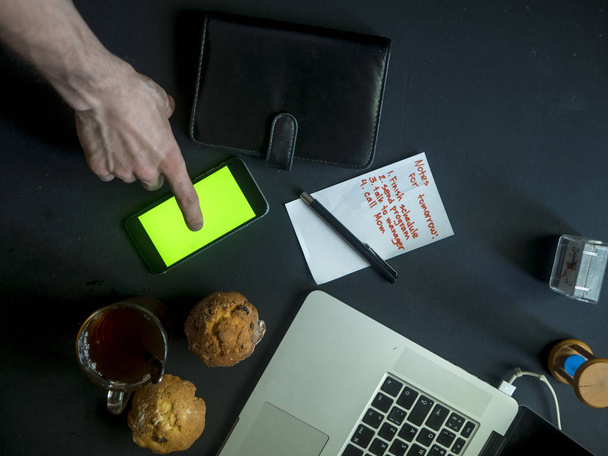 felső kéz ujj csap telefon chroma kulcsfontosságú sötét íróasztal - Fotó, kép