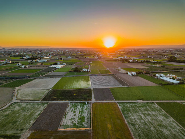 Vista desde el aire a los campos agrarios durante una brillante puesta de sol cerca de las bahías de Port Saplaya. Valencia
 - Foto, imagen