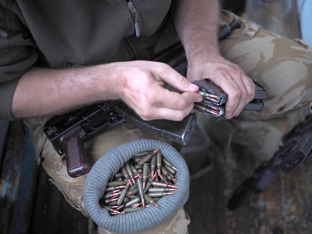 στρατιώτης φόρτωση ένα μάτσο σφαίρες σε ένα πιστόλι περιοδικό. - Φωτογραφία, εικόνα