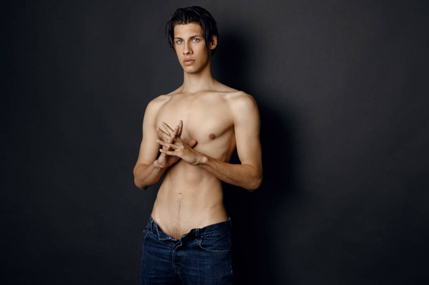 Male model in denim blue jeans on black background in studio isolated - Photo, Image