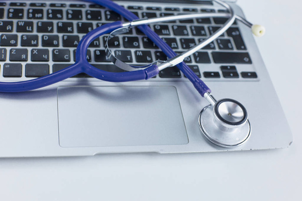 Stethoscope lying on a laptop keyboard in a concept of online m - Fotó, kép