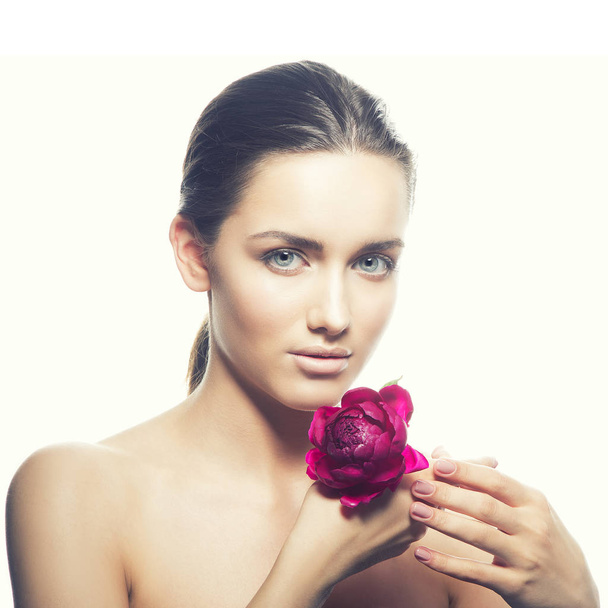 Portrait of young woman with natural makeup and peony flower on white background - Фото, изображение