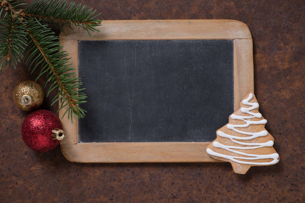 クリスマス装飾。黒板とジンジャーブレッドのクリスマス ツリー、小ぎれいなな枝とクリスマス ツリーのボール。本文の空白. - 写真・画像