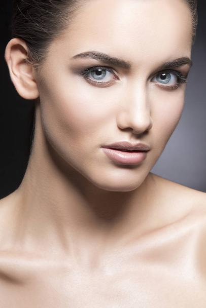 Портрет молодой женщины с натуральным макияжем на черном фоне
 - Фото, изображение