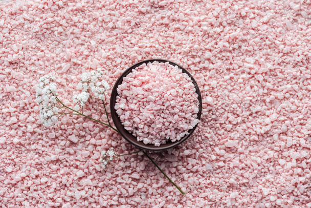 top view of pink sea salt in bowl and beautiful small white flowers - Photo, Image