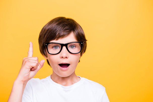 Back to school! Portrait of happy kid in glasses  isolated on yellow background with copy space. Idea and innovation concept - Zdjęcie, obraz
