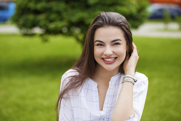 Close up portrait of beautiful young happy brunette woman with fresh and clean skin, summer street outdoors - Photo, Image