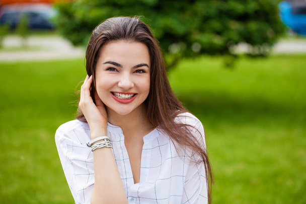 Close up portrait of beautiful young happy brunette woman with fresh and clean skin, summer street outdoors - Zdjęcie, obraz