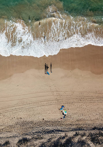 Paesaggio marino con onde e ombre di persone che camminano. Foto aerea vista dall'alto dal drone volante della natura paesaggio acqua turchese con spiaggia di Wanda in giornata invernale a Cronulla. Viaggio vacanza concetto
. - Foto, immagini