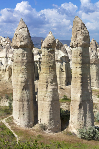 Rural landscape in the Valley of Love, Cappadocia. Large phallic rock formations against the blue summer sky. - Fotografie, Obrázek