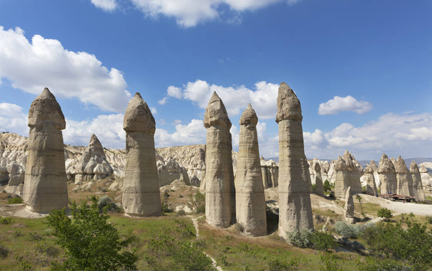 Rural landscape in the Valley of Love, Cappadocia. Large phallic rock formations against the blue summer sky. - Fotografie, Obrázek