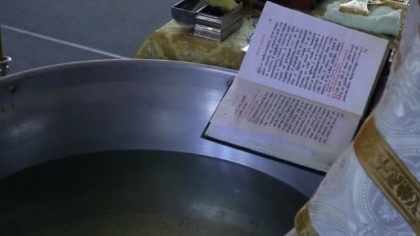 De priester leest het gebed in de buurt van het bekken van de doop - Video