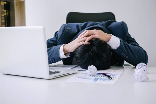Feeling stress and headache, Businessman depressed and exhausted at his desk frustrated with problems with a pile of work while hiding his face on table. - Foto, afbeelding