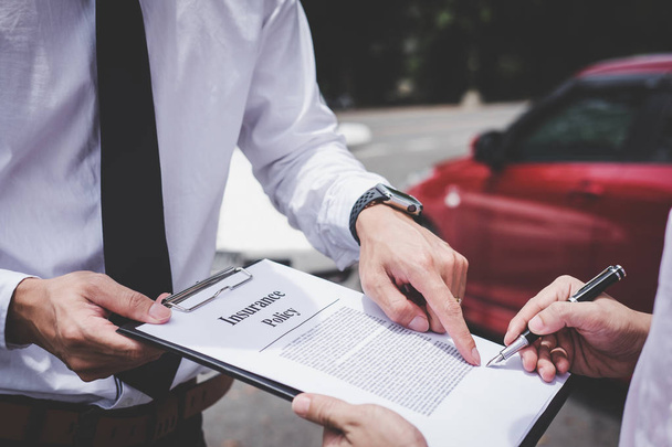 Insurance Agent examine Damaged Car and customer filing signature on Report Claim Form process after accident, Traffic Accident and insurance concept. - Photo, Image