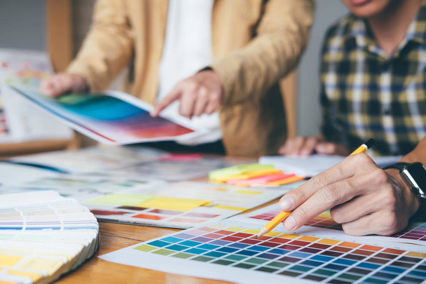 Young creative team having a meeting in creative office, Architectural drawing with work tools and accessories, Color swatch samples chart for selection coloring. - Foto, imagen