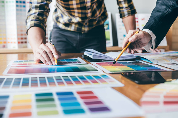 Genç yaratıcı bir toplantı yaratıcı ofis, iş araçları ve aksesuarları, renk renk örneği örnekleri grafik seçimi boyama çizim mimari sahip takım. - Fotoğraf, Görsel