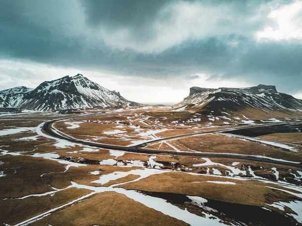Iceland aerial view Landscape with snow and clouds, street and yellow and green grass - Fotografie, Obrázek