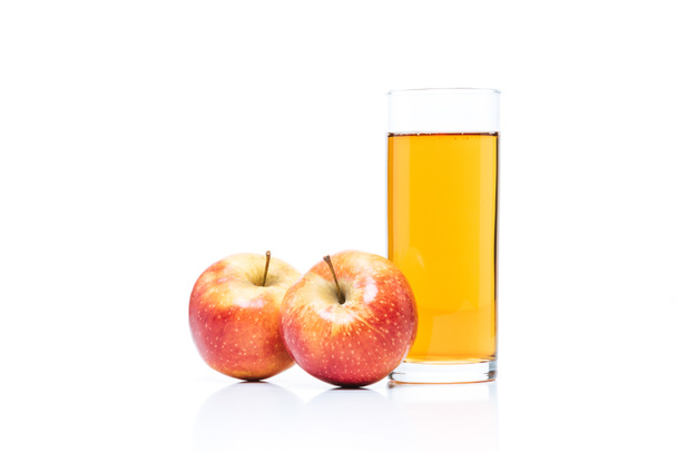 κλείνω πάνω θέα του ποτήρι χυμό μήλου και φρέσκα μήλα που απομονώνονται σε λευκό - Φωτογραφία, εικόνα