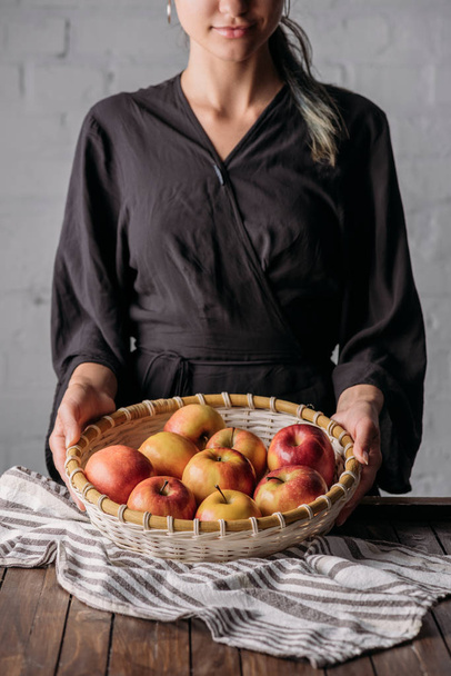 vista parcial de la canasta de mujer con manzanas frescas
 - Foto, imagen