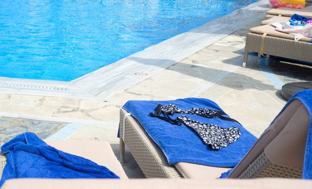 Womens swimming suit on a sunbed near the pool - Photo, Image