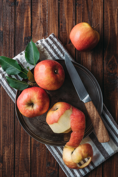 flat lay with ripe apples and knife on metal tray on wooden tabletop - Fotoğraf, Görsel