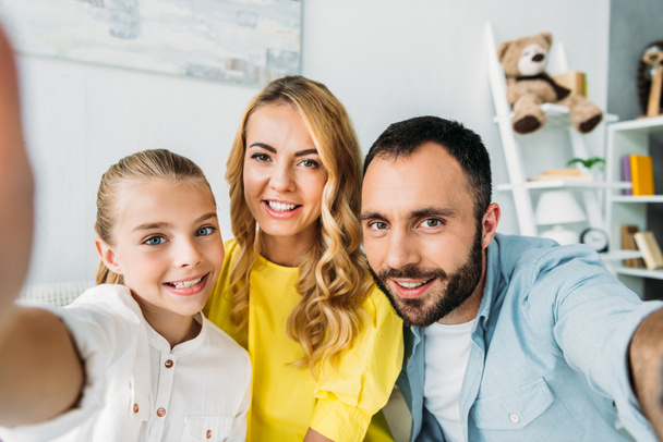 point of view of happy young family taking selfie at home - Foto, Bild