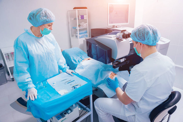 patient and team of surgeons in operating room during ophthalmic surgery - Foto, Imagem