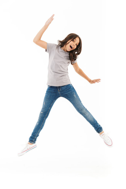 Image of cute girl jumping isolated over white wall background. - Valokuva, kuva